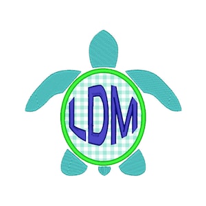 Könnte beinhalten: Eine grüne und blaue Schildkröte mit einem weißen und grünen Gingham-Kreis in der Mitte. Der Kreis enthält die Buchstaben "LDM" in Blau.