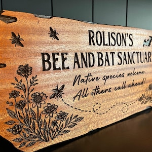 May include: A rustic wooden sign with the text "Welcome to our home" in white lettering. The sign features a distressed finish and a simple, inviting design, perfect for a front porch or entryway.