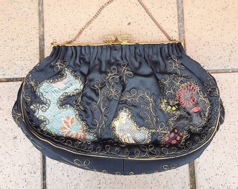 Pode incluir: Uma bolsa de noite de cetim preto com uma corrente de ouro e desenhos florais e de pássaros bordados intrincados.
