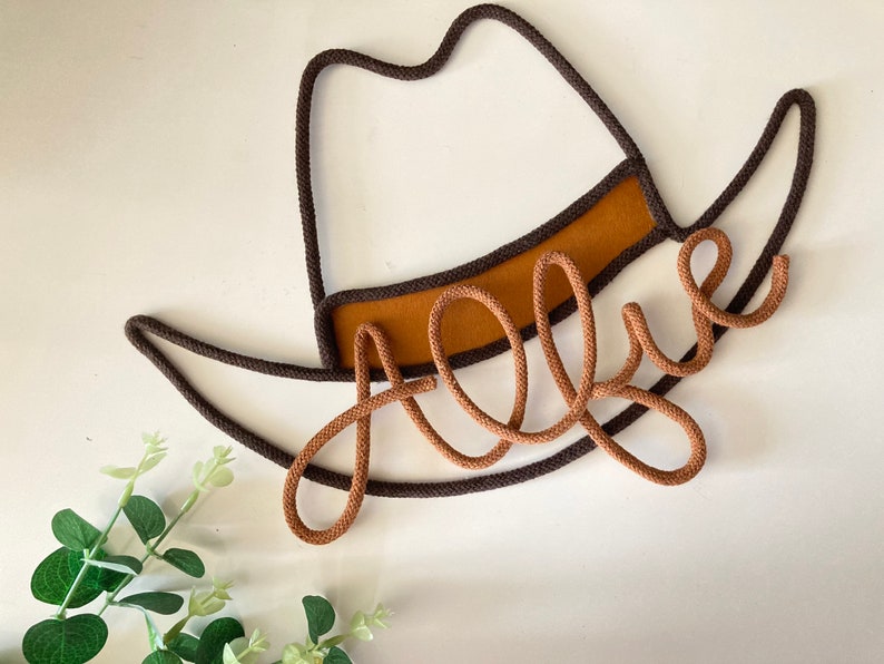 Personalized cowboy hat-shaped wall sign made of wire and rope, featuring a custom name