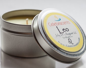 May include: A silver candle tin with a yellow label that reads "Celebriscents Leo July 23 - August 22 Net Weight oz www.Celebriscents.com" with a Leo zodiac symbol.