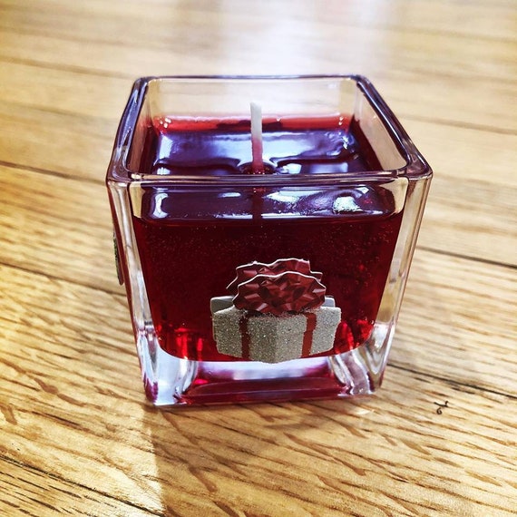 Apple-cinnamon scented long lasting gel candle in glass cube with Christmas decorations perfect for the Holiday season as a home decor.