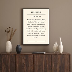 May include: A black and white printable wall art print with a quote from The Hobbit by J.R.R. Tolkien. The quote reads: "In a hole in the ground there lived a hobbit. Not a nasty, dirty, wet hole, filled with the ends of worms and an oozy smell, nor yet a dry, bare, sandy hole with nothing in it to sit down on or to eat: it was a hobbit-hole, and that means comfort."