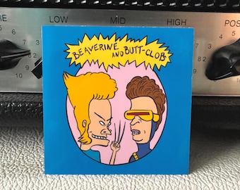 May include: A blue square sticker with a cartoon image of two characters. The text "BEAVERINE AND BUTT-CLOB" is written above the characters. One character has blonde hair and the other has brown hair and yellow glasses.