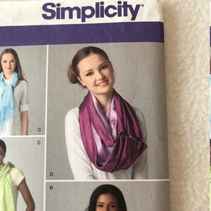 May include: A sewing pattern guide showing different ways to tie a scarf. The pattern includes instructions for a light blue scarf, a green scarf, a purple scarf, and a pink scarf.