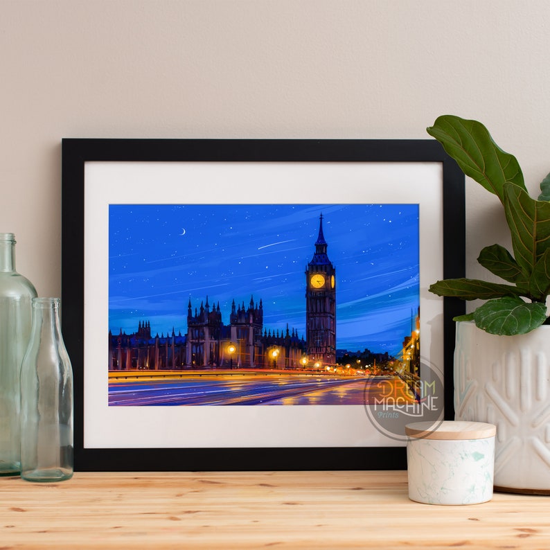 Peut inclure: Une impression encadr&eacute;e d'une ville nocturne avec la tour de l'horloge Big Ben en arri&egrave;re-plan. Le ciel est bleu fonc&eacute; avec des &eacute;toiles et une lune croissante. Les b&acirc;timents sont &eacute;clair&eacute;s de lumi&egrave;res jaunes, et des voitures circulent sur la route au premier plan.