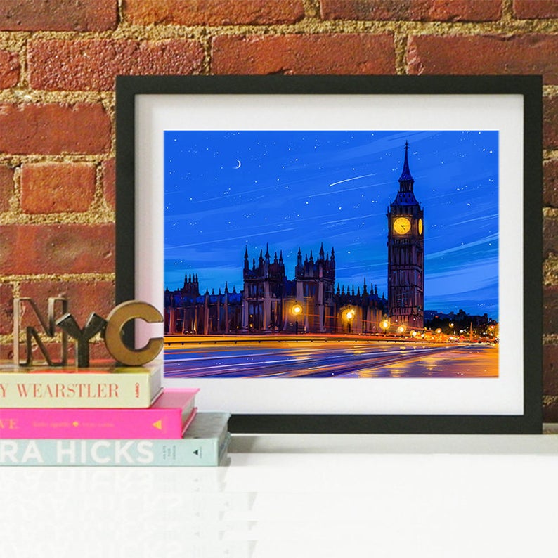 Peut inclure: Une illustration encadr&eacute;e du palais de Westminster et de Big Ben &agrave; Londres, en Angleterre, de nuit. Le ciel est bleu avec une lune croissante et des &eacute;toiles. Les b&acirc;timents sont &eacute;clair&eacute;s de lumi&egrave;res jaunes. La rue devant les b&acirc;timents est humide et r&eacute;fl&eacute;chissante.