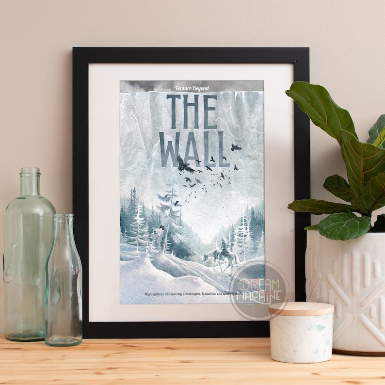 May include: A framed print with a watercolor illustration of a snowy landscape with a forest and a path. The text "Venture Beyond THE WALL" is at the top of the print. The quote "Night gathers, and now my watch begins. It shall not end until my death." is at the bottom of the print.