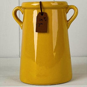 May include: A vibrant yellow ceramic vase with two loop handles. A small brown tag is attached, bearing the handwritten words "For you". The vase has a glossy finish and a gently flared form.