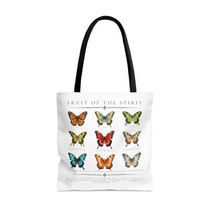 May include: White tote bag with black handles featuring a colorful butterfly design. The design includes the words "Fruit of the Spirit" and the names of the fruits of the spirit. The bag is made of a durable material.