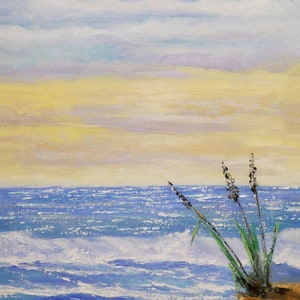以下が含まれることがあります： 青い海と黄色と青の空の下の海岸のシーンを描いた油絵。波が海岸に打ち寄せ、紫色の花を持つ緑の植物の塊が小さな崖に生えています。 作品は左下に署名されています。