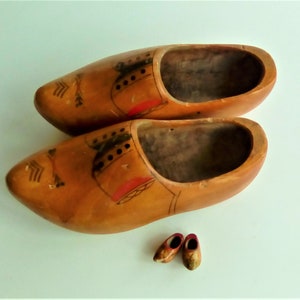 Genuine Dutch wooden clogs from the 1970s
     Traditional hand-carved and painted to imitate a gentleman's shoes in bright colours.
      Unusual planters for your tulip bulbs or hanging as a wall vase. Used
       30cm long 12cm wide 12cm high.