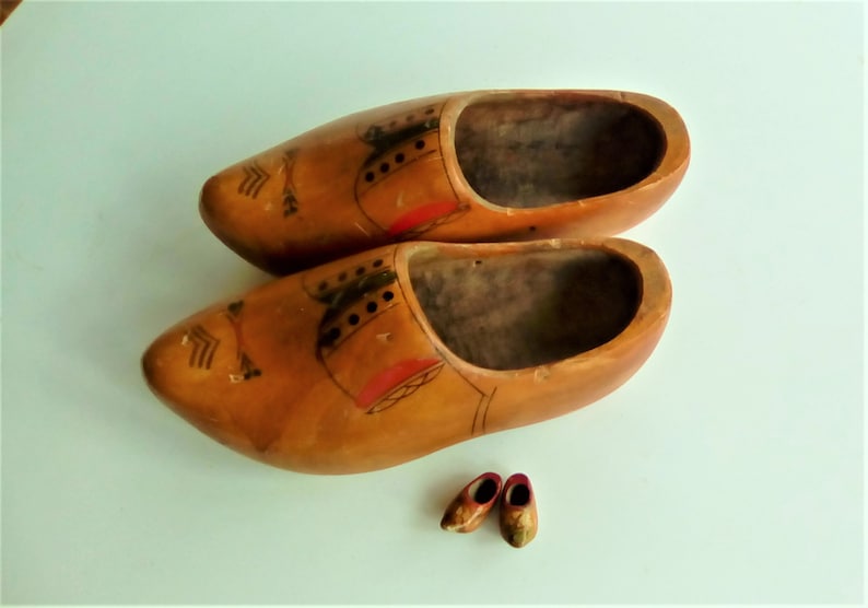 Genuine Dutch wooden clogs from the 1970s
     Traditional hand-carved and painted to imitate a gentleman's shoes in bright colours.
      Unusual planters for your tulip bulbs or hanging as a wall vase. Used
       30cm long 12cm wide 12cm high.