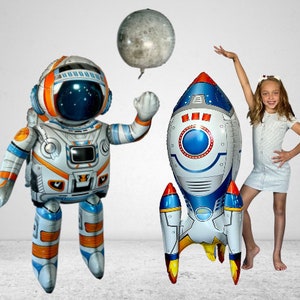 May include: A set of three inflatable space-themed party decorations: a blue and white rocket, a white astronaut with an orange visor, and a gray moon balloon.