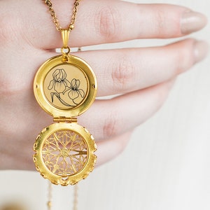 May include: A gold locket necklace with a delicate chain. The locket features a floral design on the front and a filigree pattern on the back.