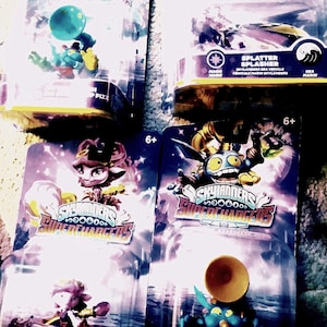 May include: Four Skylanders SuperChargers action figures in their original packaging. The figures include Splatter, Big Bubble Pop Fizz, and Splatter Splasher. Each package features character art and the "6+" age rating.