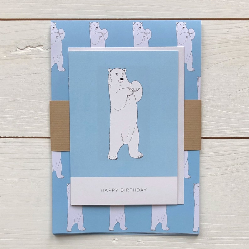 May include: A blue and white birthday card with a polar bear illustration and the text "Happy Birthday". The card is wrapped in blue wrapping paper with a repeating pattern of polar bears.