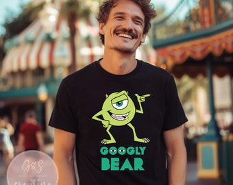 Puede incluir: Una camiseta negra con un gráfico de monstruo verde de un ojo y el texto "GOOGLY BEAR" en verde.