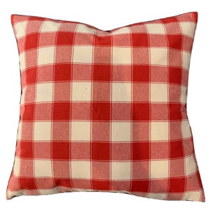 Könnte beinhalten: Rotes und weißes kariertes Kissen mit dunkelblauem Rand.