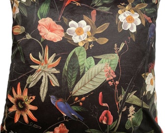 May include: Square decorative pillow with a dark background featuring a botanical print. The design includes colorful flowers, green leaves, and birds in shades of red, orange, white, and blue. The pillow is likely made of a soft, textured fabric.
