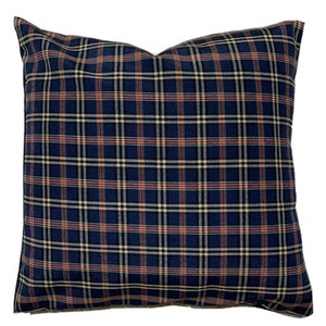May include: A blue, red, and white plaid throw pillow. The pillow is made of a soft, woven fabric.