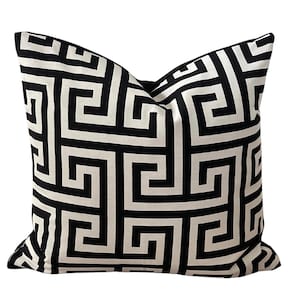 May include: Black and white geometric patterned throw pillow with a Greek key design.