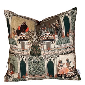 Puede incluir: Una almohada decorativa con fondo beige y un dise&ntilde;o colorido de inspiraci&oacute;n india. El dise&ntilde;o presenta patrones intrincados, arcos y figuras en tonos de verde, naranja y azul.