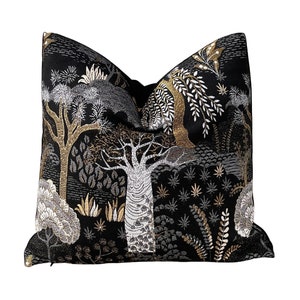 May include: Black throw pillow with a gold and silver embroidered design of trees and foliage.