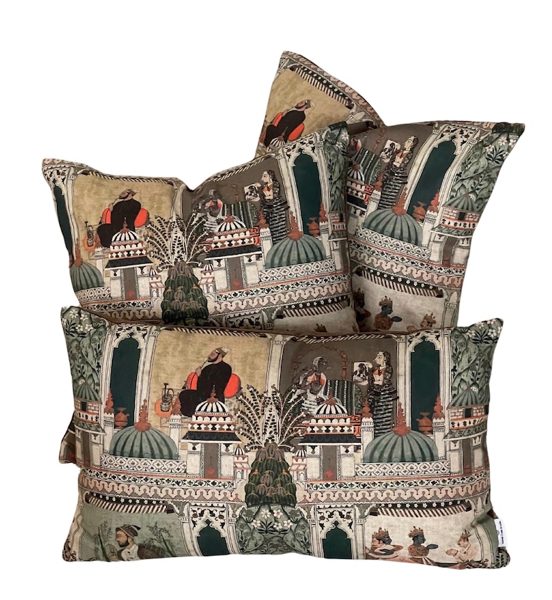 Puede incluir: Tres almohadas decorativas con un dise&ntilde;o estampado en verde, marr&oacute;n y beige que presenta una ilustraci&oacute;n intrincada de personas en un entorno de palacio.