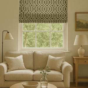 Puede incluir: Interior de salón con un sofá beige, cojines y una mesa de centro redonda de madera. Una persiana estampada cubre la ventana. Se ven una lámpara de pie y una lámpara de mesa. Un jarrón con vegetación y un cuenco decorativo están sobre la mesa.