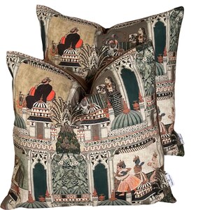 Puede incluir: Dos almohadas decorativas con un dise&ntilde;o estampado en verde, marr&oacute;n y crema que representa una escena de palacio indio con personas con ropa tradicional.