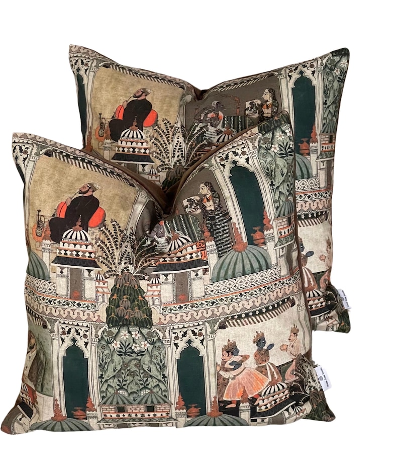 Puede incluir: Dos almohadas decorativas con un dise&ntilde;o estampado en verde, marr&oacute;n y crema que representa una escena de palacio indio con personas con ropa tradicional.