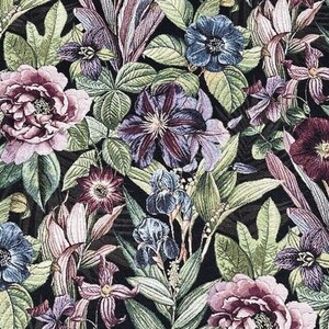 May include: A dark background with a floral pattern featuring various flowers in shades of purple, pink, blue, and green. The flowers are arranged in a random pattern and are surrounded by leaves.