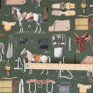 May include: A green fabric with a repeating pattern of equestrian equipment, including saddles, bridles, stirrups, and other horse tack. The fabric features a brown leather saddle, a white horse, and a brown leather bridle.