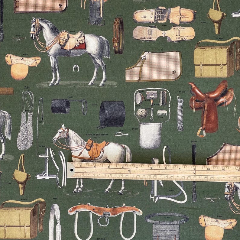 May include: A green fabric with a repeating pattern of equestrian equipment, including saddles, bridles, stirrups, and other horse tack. The fabric features a brown leather saddle, a white horse, and a brown leather bridle.