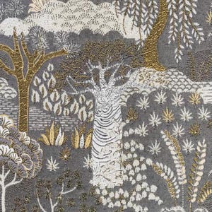 May include: A gray fabric with a white and gold patterned design of trees and leaves. The fabric has a textured surface.