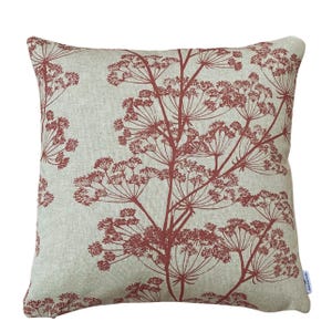 May include: Square decorative pillow with a light beige background and a repeating pattern of reddish-brown botanical illustrations. The pillow has a textured appearance and a simple, elegant design, suitable for home decor.