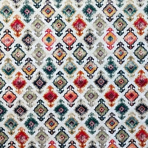 May include: A fabric with a repeating geometric pattern. The design features diamond shapes in red, orange, green, and gold, set against a white background. The pattern has an ornate, vintage aesthetic, suitable for various textile projects.