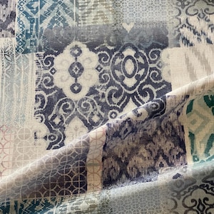 Peut inclure: Tissu textile avec un motif patchwork. Le tissu présente un mélange de motifs géométriques et floraux dans des tons de bleu, gris et blanc. Le motif comprend des carrés et des rectangles avec divers motifs, créant un aspect texturé et superposé.