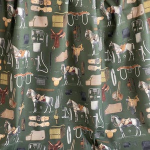 May include: A green fabric with a repeating pattern of horses, saddles, bridles, and other equestrian equipment. The pattern is in shades of brown, white, and black.