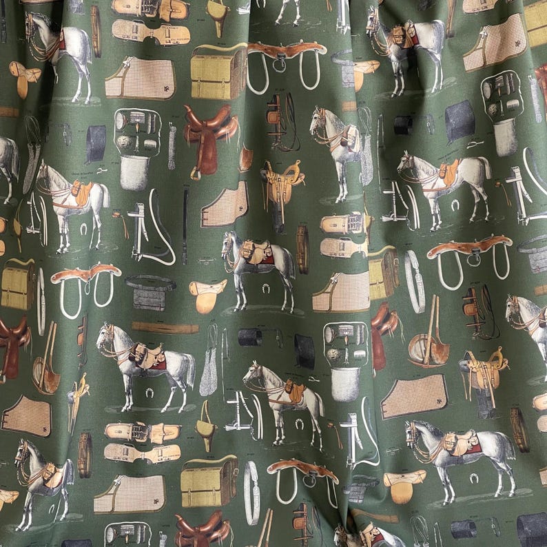 May include: A green fabric with a repeating pattern of horses, saddles, bridles, and other equestrian equipment. The pattern is in shades of brown, white, and black.
