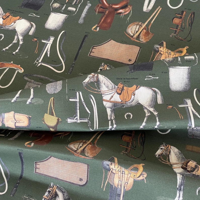 May include: A green fabric with a repeating pattern of equestrian equipment, including saddles, bridles, stirrups, and horses. The fabric is perfect for crafting projects, upholstery, or home decor.