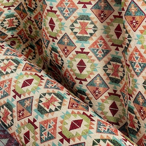 May include: Close-up of a fabric with a geometric pattern in shades of red, orange, green, blue, and beige. The pattern features repeating diamond shapes with intricate details.