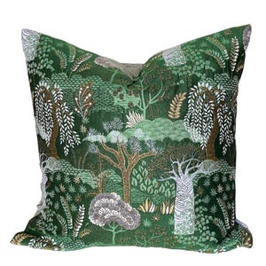 May include: Green throw pillow with a forest scene featuring trees, leaves, and gold accents.