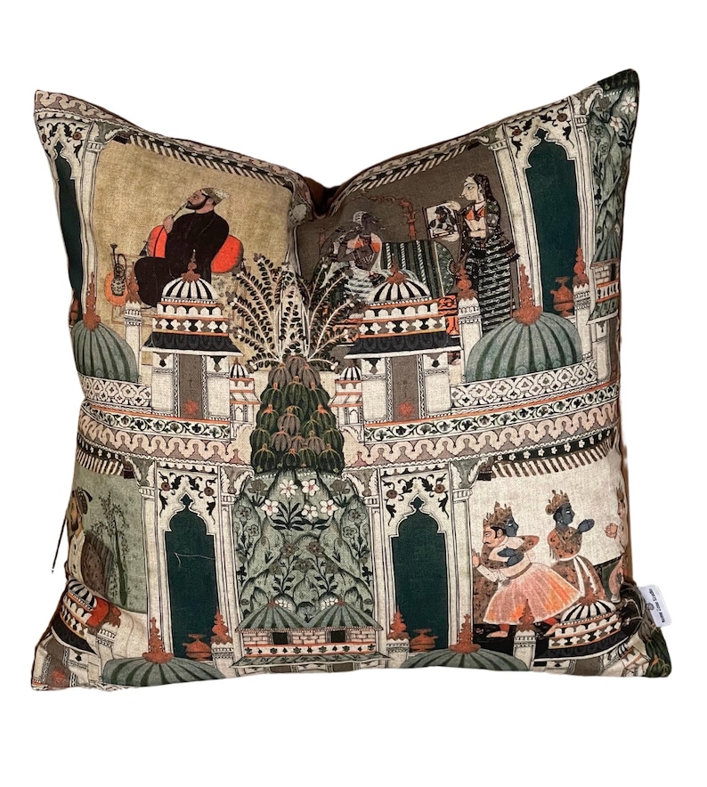 Puede incluir: Una almohada decorativa con fondo beige y un dise&ntilde;o colorido de inspiraci&oacute;n india. El dise&ntilde;o presenta patrones intrincados, arcos y figuras en tonos de verde, naranja y azul.