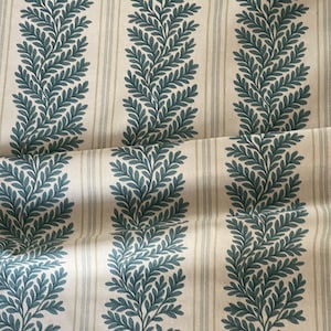 May include: Fabric featuring a cream background with vertical stripes and teal leaf motifs. The leaf pattern consists of repeating, stylized branches with detailed leaves. The fabric has a soft, textured look, ideal for home furnishings or clothing.