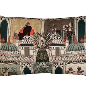 Puede incluir: Coj&iacute;n rectangular con un dise&ntilde;o estampado en verde, beige y naranja que representa una escena intrincada de personas en un entorno palaciego. El dise&ntilde;o incluye arcos, c&uacute;pulas y palmeras.