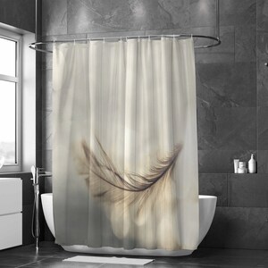 May include: A beige shower curtain with a single brown feather in the center. The feather is translucent and appears to be floating in the air. The background is a soft, blurred beige.