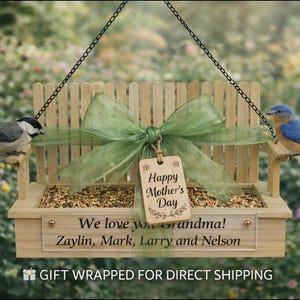 May include: A wooden bird feeder with a green bow and a tag that reads "Happy Mother's Day." The feeder is personalized with the text "We love you grandma!" and the names Zaylin, Mark, Larry, and Nelson. Two birds perch on the feeder.