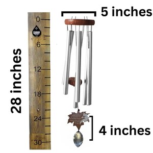 May include: Silver wind chime with a wooden top and a crystal prism at the bottom. The chime is 28 inches long and has a leaf-shaped charm with the text "Through the strongest storms the truest hearts will always find their way home".
